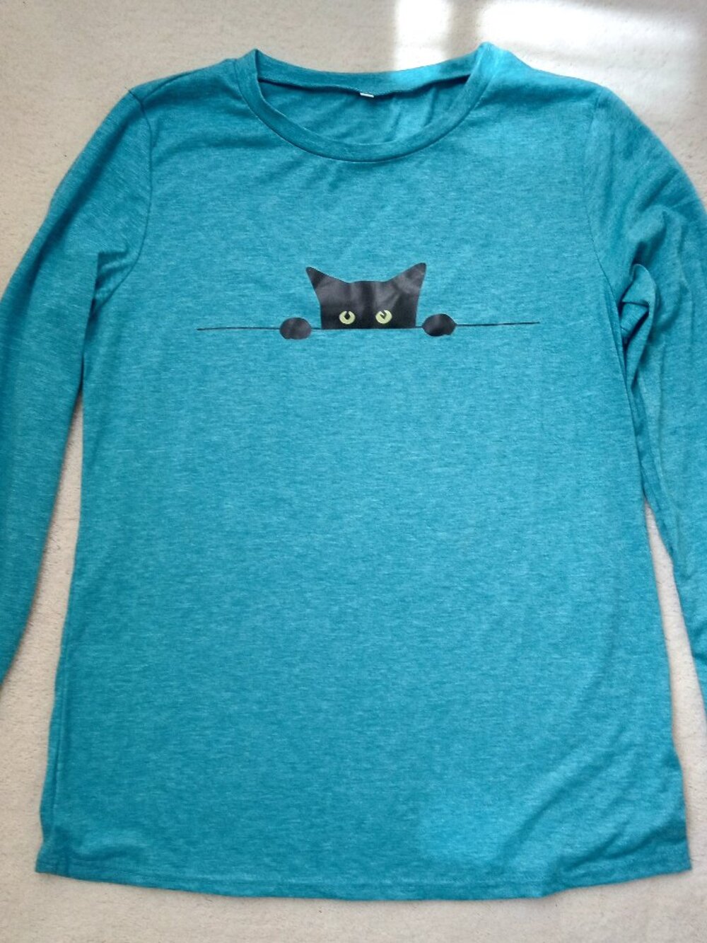 Black cat peeking out on long-sleeved top == Medium. New, never worn.